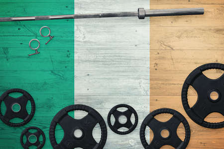 Ireland gym concept. Top view of heavy weight plates with iron bar on national background.の写真素材