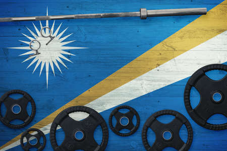 Marshall Islands gym concept. Top view of heavy weight plates with iron bar on national background.の写真素材