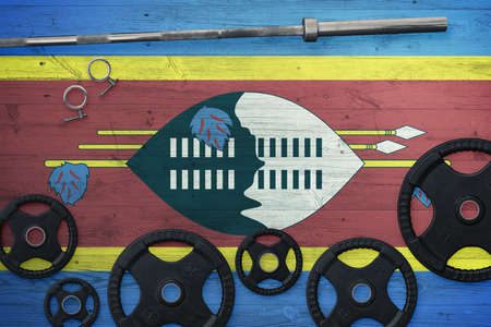 Swaziland gym concept. Top view of heavy weight plates with iron bar on national background.の写真素材
