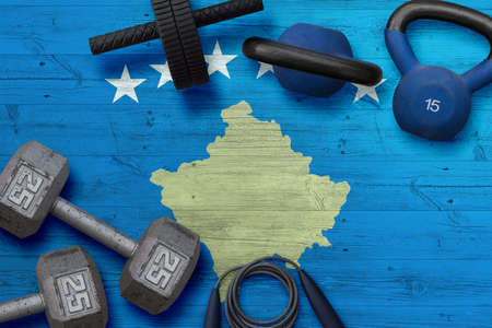 Kosovo sports club concept. Top view of heavy weight plates with iron bar on national background.の写真素材