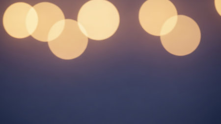 A close-up image of soft, glowing bokeh lights against a dark background, creating a dreamy and serene atmosphere.の素材