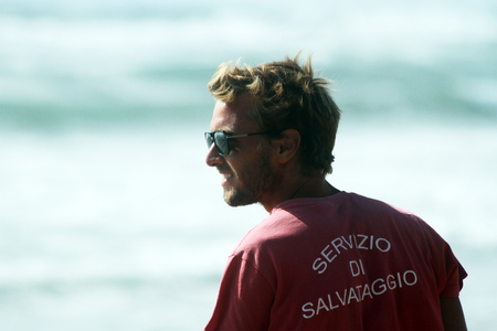 Lifeguard on the beach looking carefully at the sea. Rough sea in the background. Sabaudia, Lazio, Italyのeditorial素材
