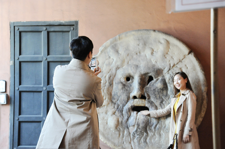 Rome, Italy â October 10, 2018: Asian man and woman photograph each other in front of the mouth of truth (Bocca della VeritÃ ). Church of Santa Maria in Cosmedin in Rome, Italyのeditorial素材