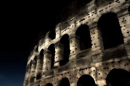 A section of the facade of the Colosseum (Flavian Amphitheatre) in Rome during the blue hour. Night...