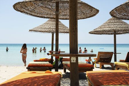 People enjoying together in the colorful turquoise sea water on sunny day in beautiful beach. Straw...