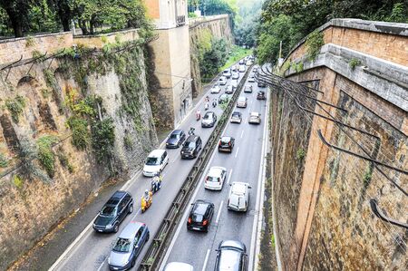 Top view of a busy street in the ancient city of Rome, Italy - Street is full of cars and scooters - Many vehicles stuck in traffic jam - big problem of traffic and air pollution in the ancient citiesの写真素材