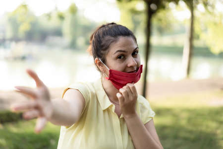 Smiling woman enjoy life at the park breathing fresh air after coronavirus outbreak - New normal concept of people having fun lowering protective mask for restart outdoors activities - Copy space textの写真素材