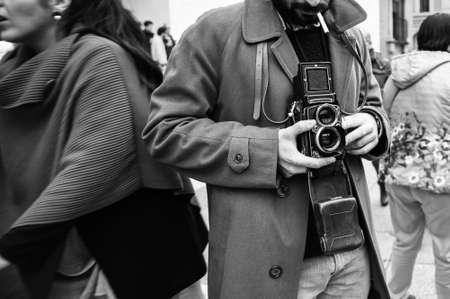 Hipster guy with the vintage camera photographing people in the city - Photojournalist with a famous retro camera taking photo in the crowd during street demonstration - Street photography style - B & Wの写真素材