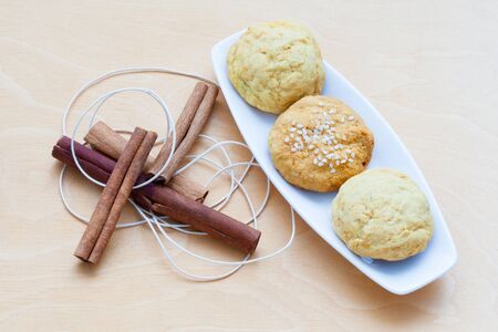 biscuits on a plate and cinnamon sticksの写真素材