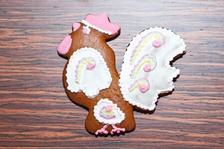 Gingerbread in the form of a cock on a wooden backgroundの写真素材