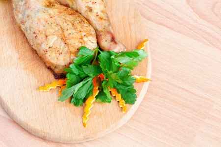 Fried chicken legs with parsley on the boardの写真素材