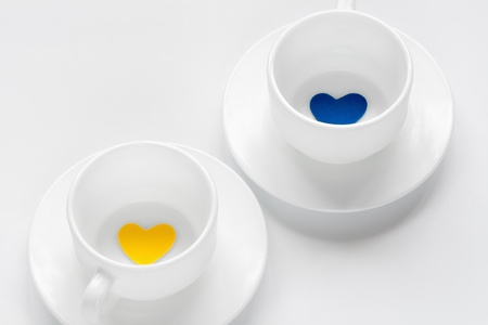 empty cup and saucer with hearts on whiteの写真素材