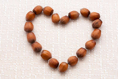 hazelnuts on a wooden background in the form of heartの写真素材