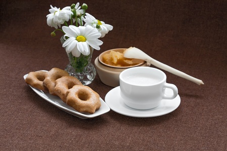 honey, cookies, and a vase of daisies on a fabric backgroundの写真素材