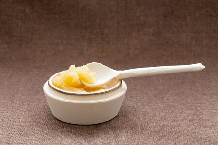 Pot of honey and wooden dipper on a sackcloth backgroundの写真素材