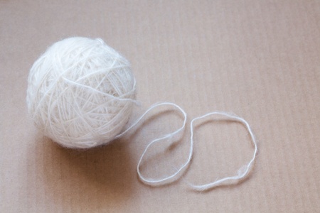 Ball of white wool yarn on cardboard backgroundの写真素材