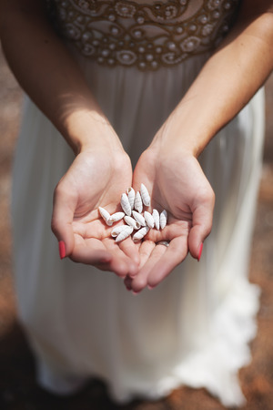 Woman holding small shell in her hands.の写真素材