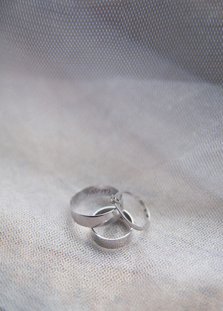 Platinum engagement and wedding ringson on fabric background.の写真素材