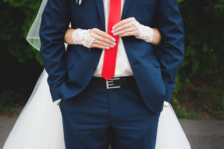 Wedding day. happy married couple bride and groom. Woman holds on mans tie.の写真素材