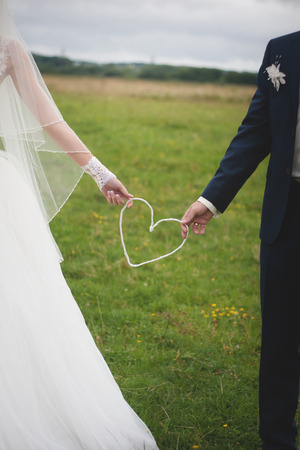 Wedding day. Bride and groom outdoor portrait with white heart.の写真素材