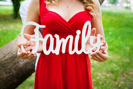 The word Family in the hands of a girl in a red dressの写真素材