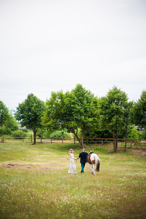 Young Couple and Horse walk in the summerの写真素材