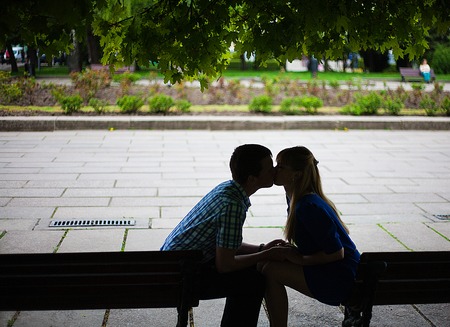 couple in love sitting on a bench and kissing.の写真素材