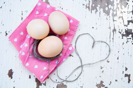 Top view of three eggs on rose napkin.の写真素材