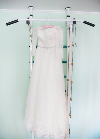 Modern white wedding dress hanging on the hangerの写真素材