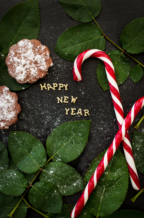 inscription of new year on a black board with cupcakes and candy red.の写真素材