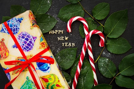 inscription of new year on a black board with gift and red candy.の写真素材