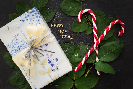 inscription of new year on a black board with a nice gift and candy-red closeupの写真素材
