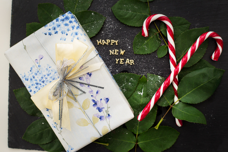 inscription of new year on a black board with a nice gift and candy-red closeupの写真素材