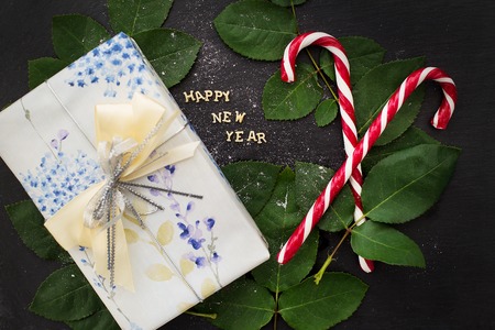 inscription of new year on a black board with a nice gift and candy-red closeupの写真素材
