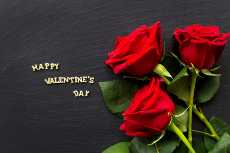 The inscription "Happy Valentine" and bright red rosesの写真素材
