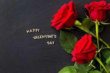 The inscription "Happy Valentine" and bright red rosesの写真素材