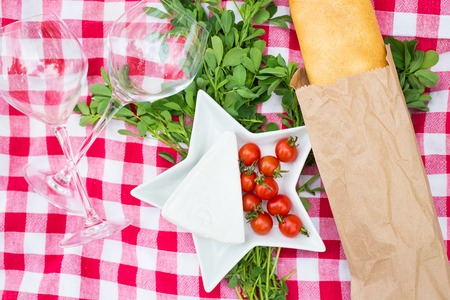 glasses, bread and cheese on a red tableclothの写真素材