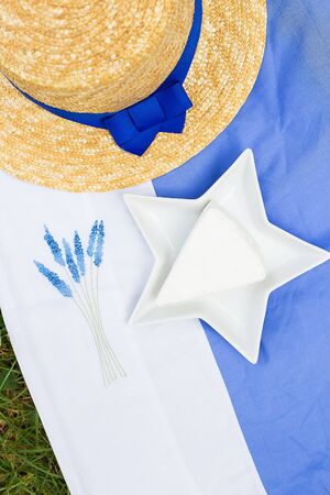 hat, brie cheese in a plate on a blue tableclothの写真素材