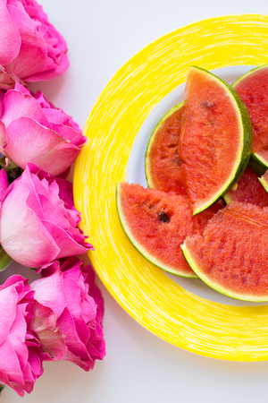 bouquet of pink roses on the table with watermelon, close-upの写真素材