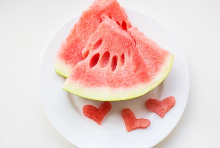 on the plate are two pieces of watermelon and a small heart-shapedの写真素材