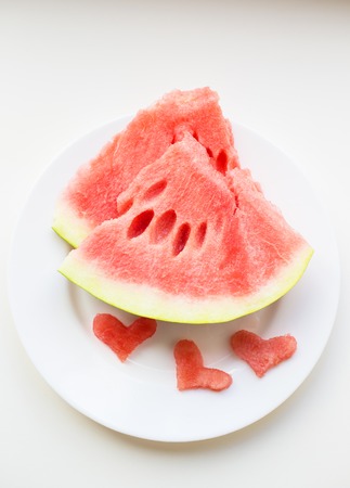 on the plate are two pieces of watermelon and a small heart-shapedの写真素材