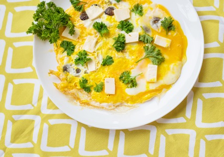 Scrambled eggs with fresh herbs on a plateの写真素材