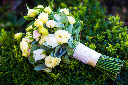 beautiful bridal bouquet lying on the green grassの写真素材