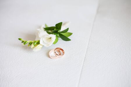 rings and flowers. Groom's boutonniere closeup. Wedding boutonniere of roses.の写真素材
