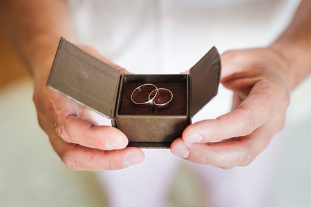groom holding a beautiful box with wedding ringsの写真素材