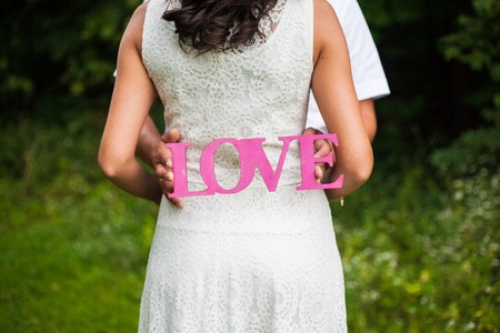 wooden pink love letter in the hands of the youngの写真素材