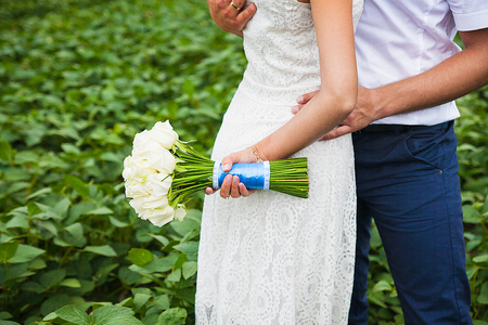 bride and groom holding a beautiful wedding bouquetの写真素材