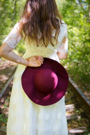 A girl in a white dress with cherry hat in the woodsの写真素材