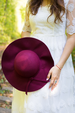 A girl in a white dress with cherry hat in the woodsの写真素材