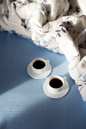 two cups of coffee in bed, sunlightの写真素材